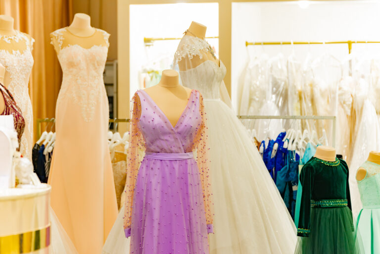 Evening elegant dresses on a shop window of a fashion boutique and on a hanger of a store for sale