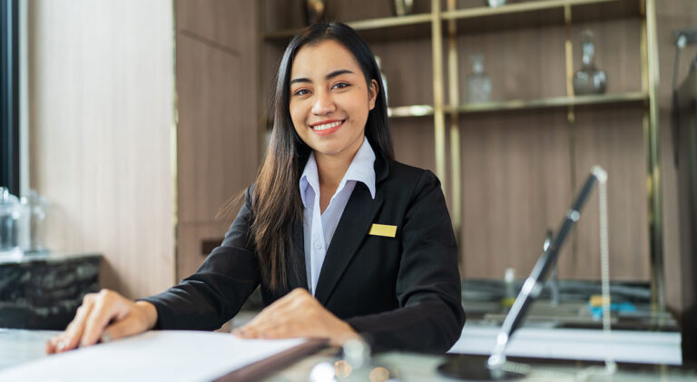 Beautiful asian hotel receptionist in uniforms at desk in lobby