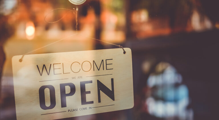 A business sign that says ‘Open’ on cafe or restaurant hang